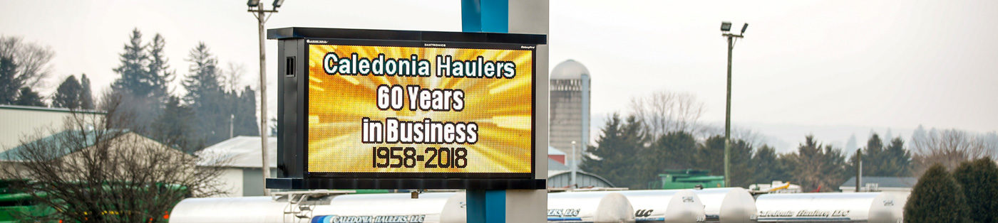CaledoniaHaulers CommunitySignHdr2 Caledonia Haulers Truck Picking Up Delivery from Farm